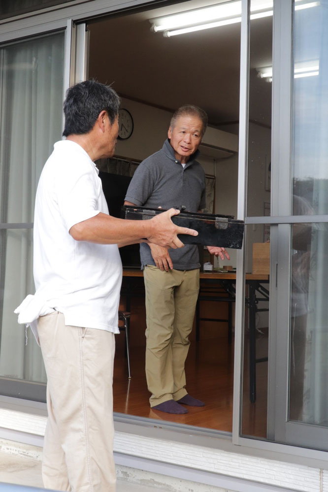 掃き出し窓でご神体を受け渡す