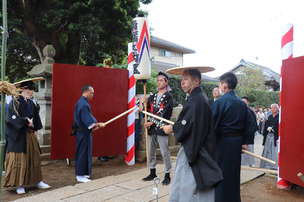 開門（羽織袴姿の門番と6尺棒を持つ案内役）